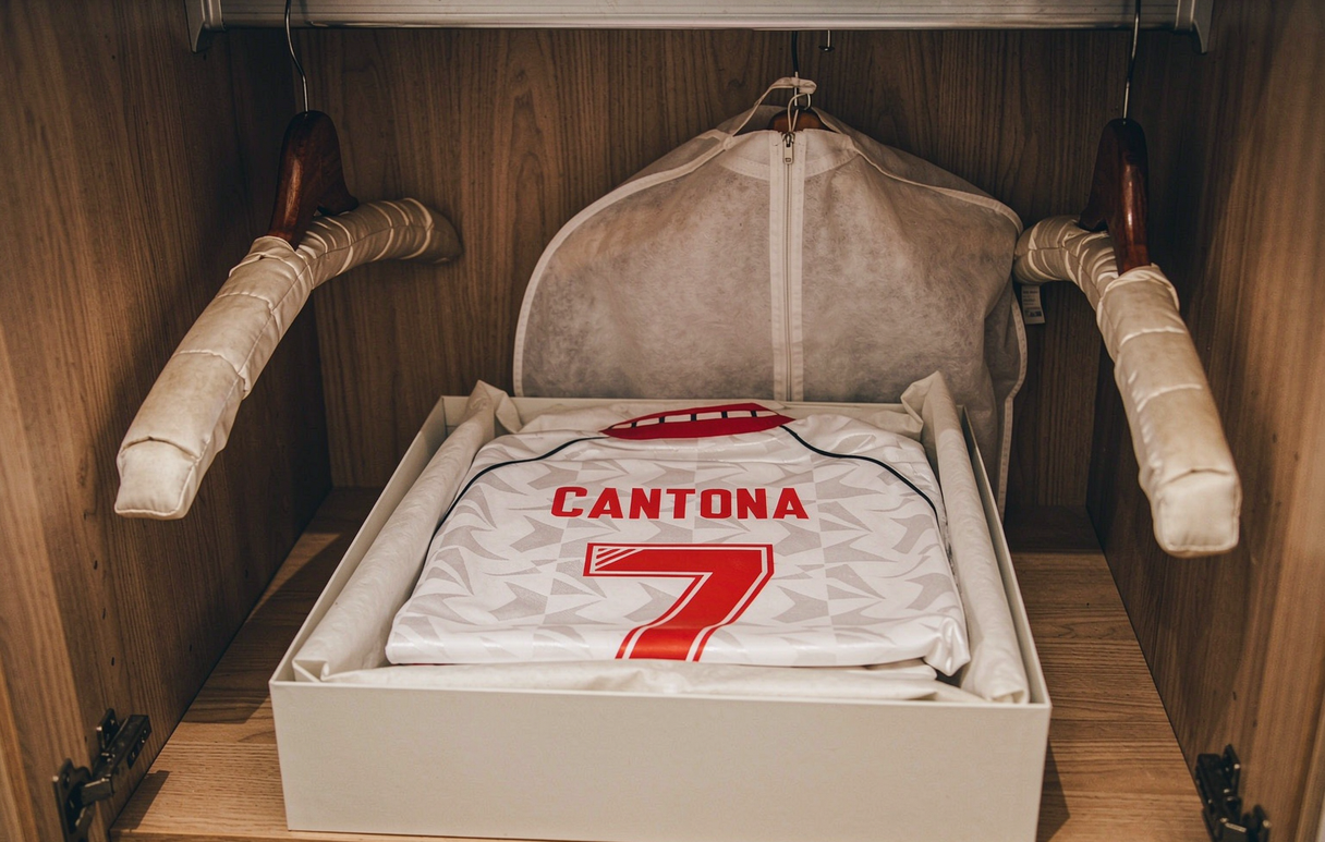 A 1991 Manchester United Cantona 7 away reissue folded with acid-free tissue in a wardrobe