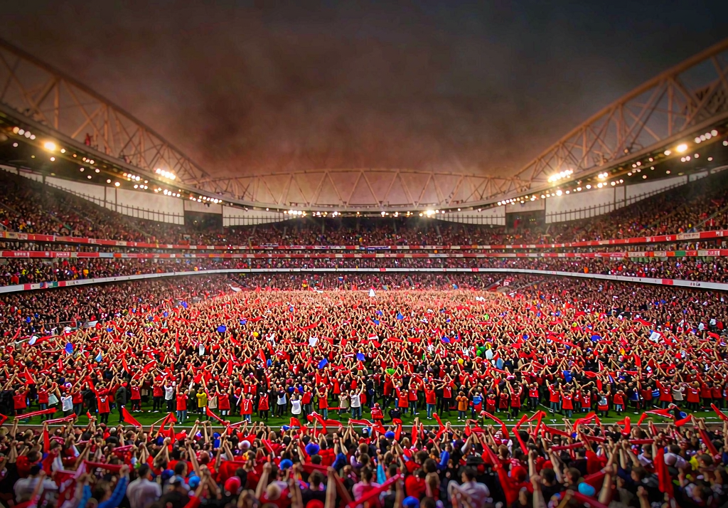 Arsenal fans at Emirates Stadium with red and white scarves raised
