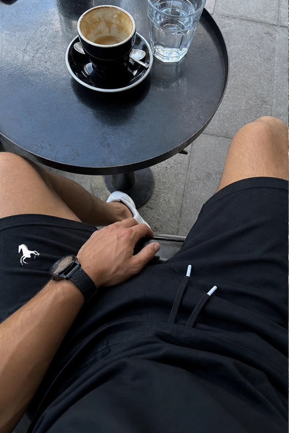 Schwarze Polo-Shorts aus der Ich-Perspektive im Café
