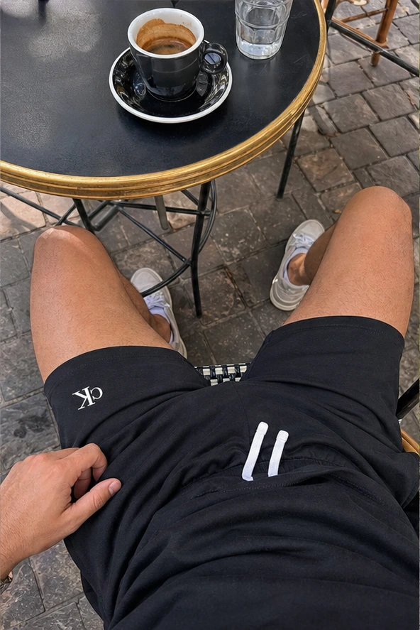 Schwarze Shorts aus der Ich-Perspektive im Café
