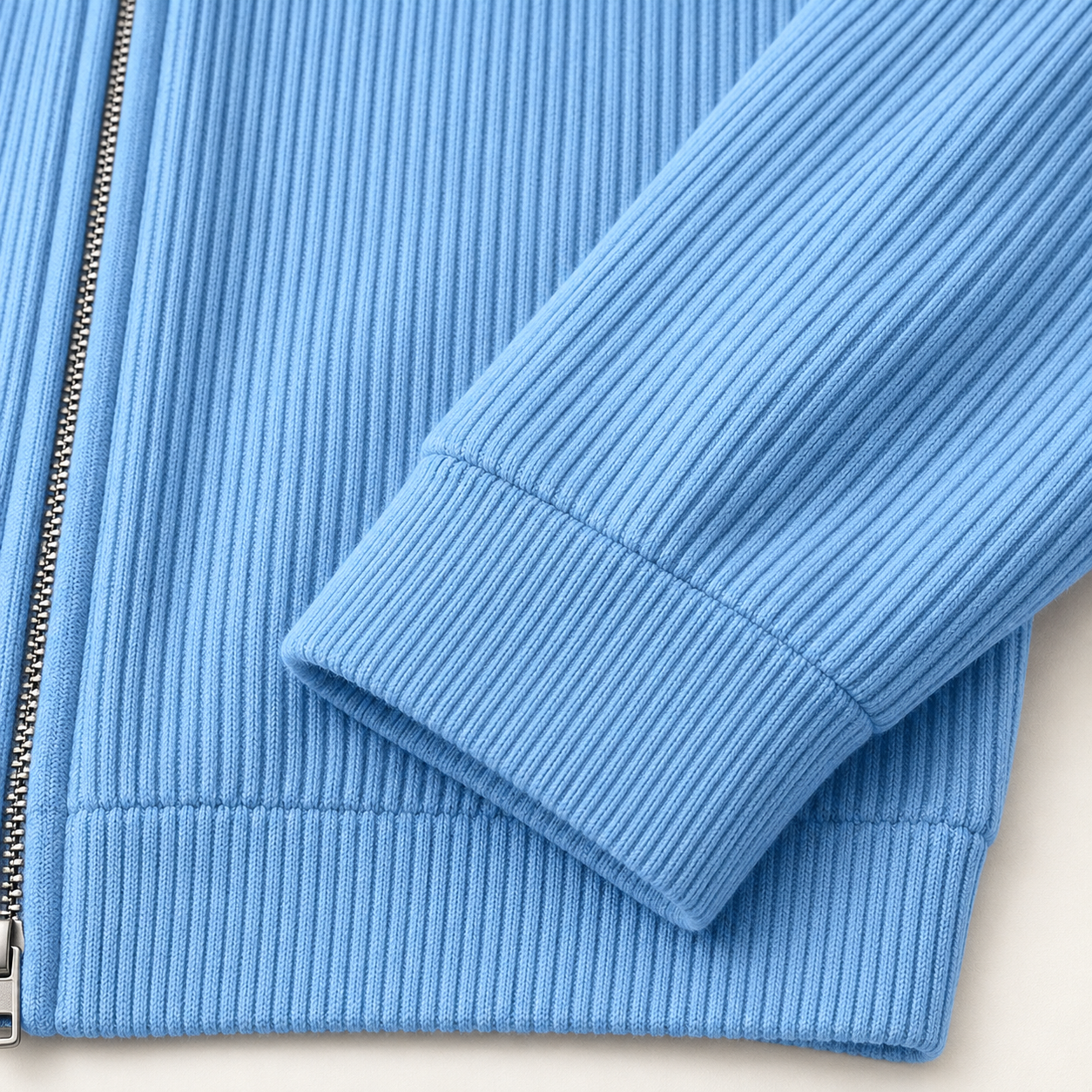 Close detail of the blue ribbed sleeve cuff arranged across the body fabric