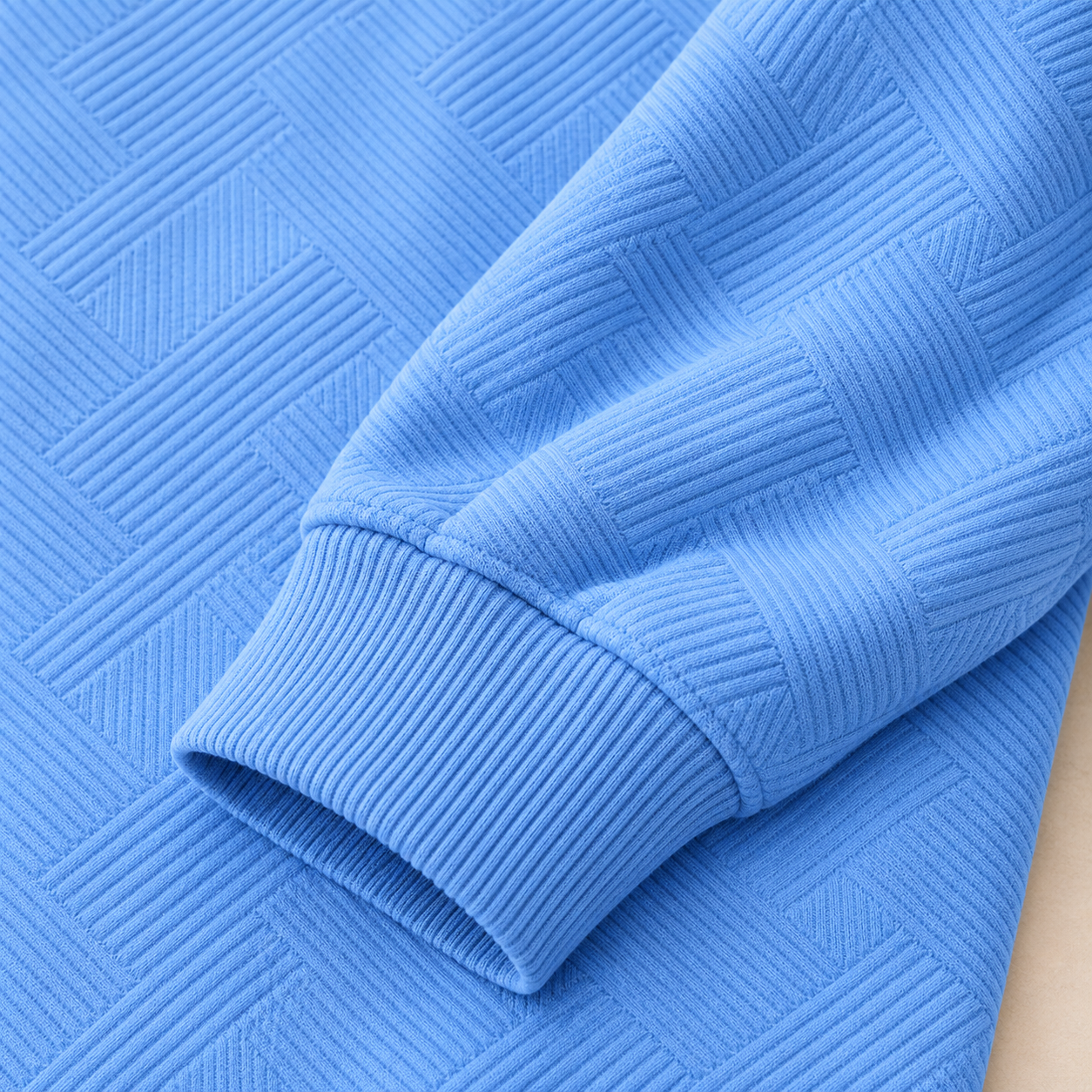 Macro view of the Sky Blue geometric textured body and vertically ribbed sleeve cuff