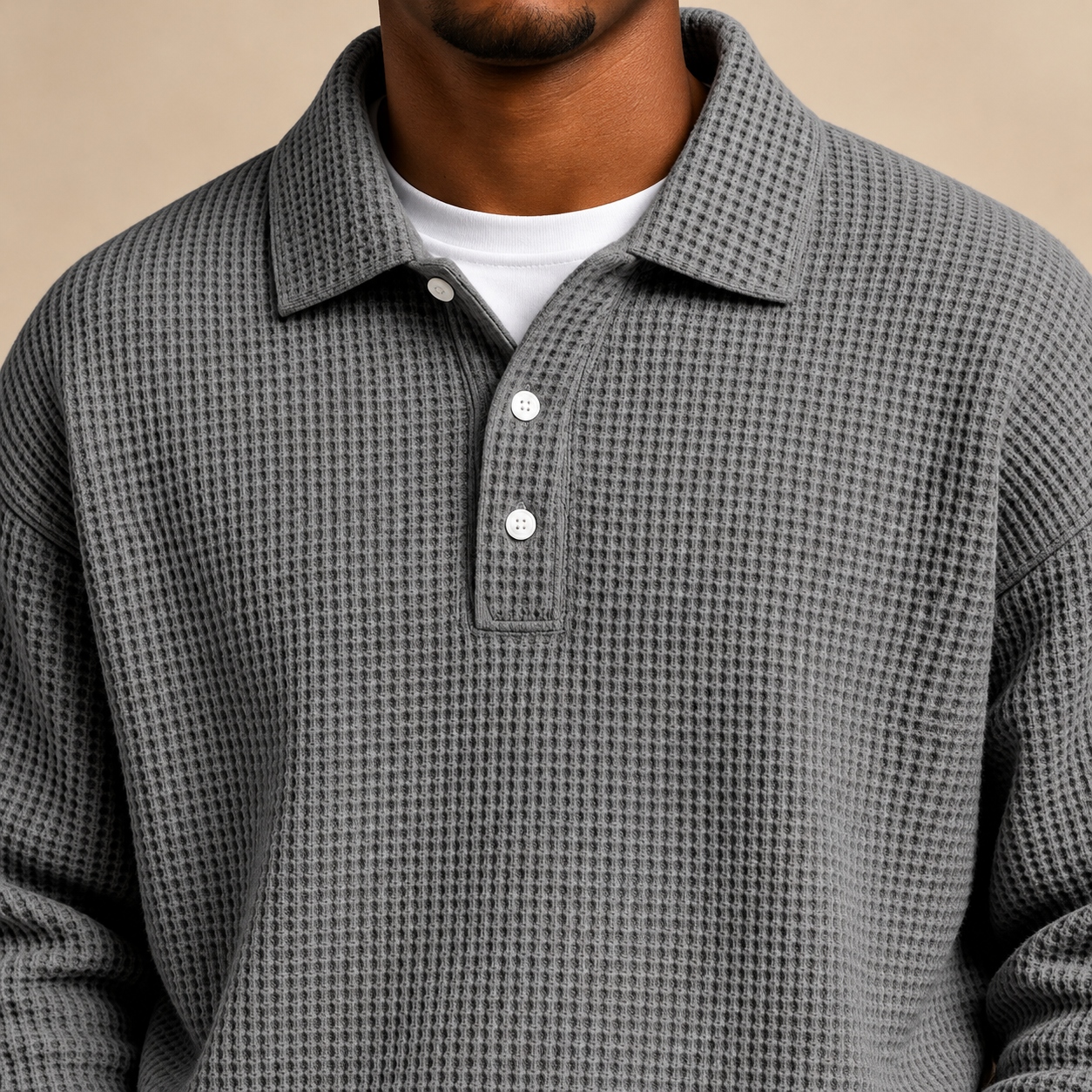 Close-up of gray waffle polo collar, three white buttons and white base layer