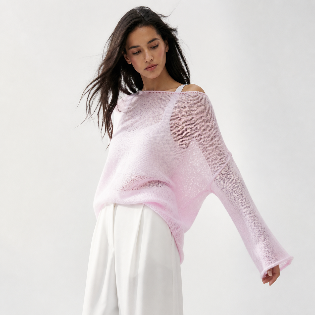 Pink airy knit sweater in an editorial studio look