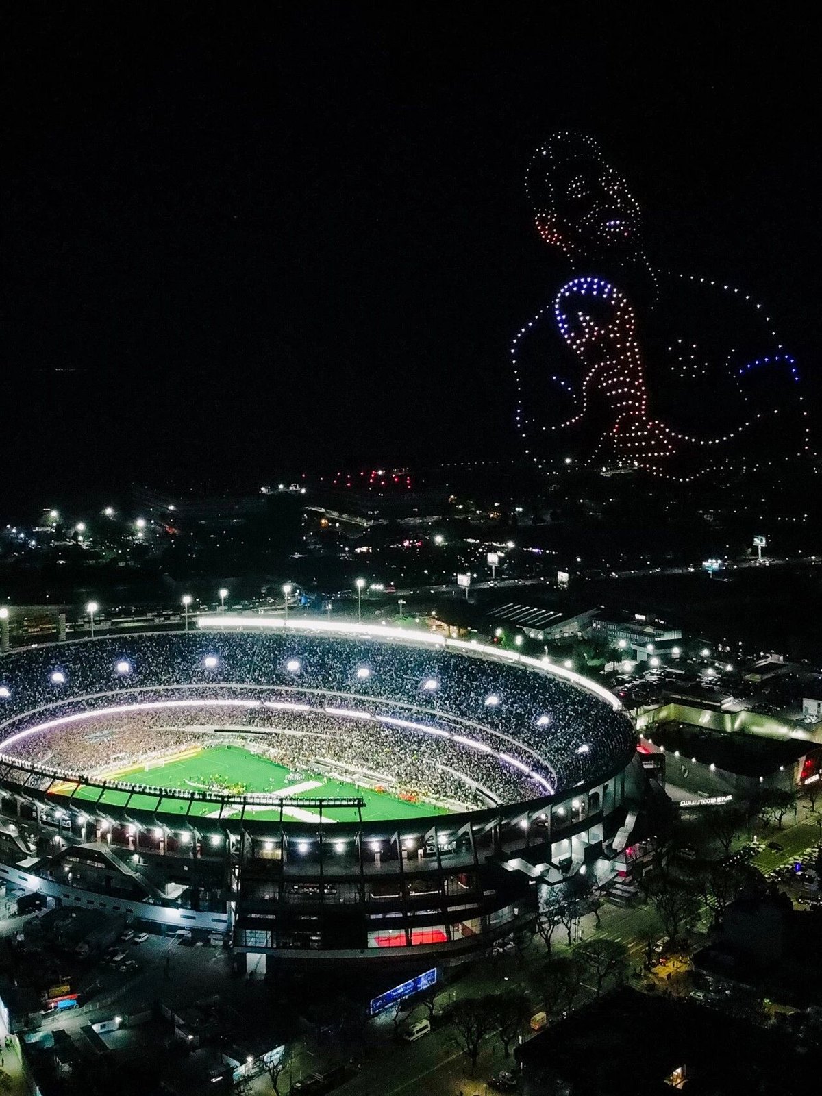 The Monumental at night with a drone image of Messi above the stadium