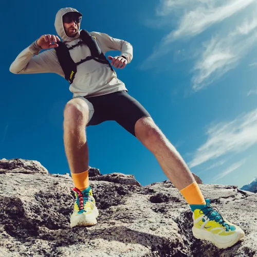 Man running on a rock while wearing the Mafate X Hike.