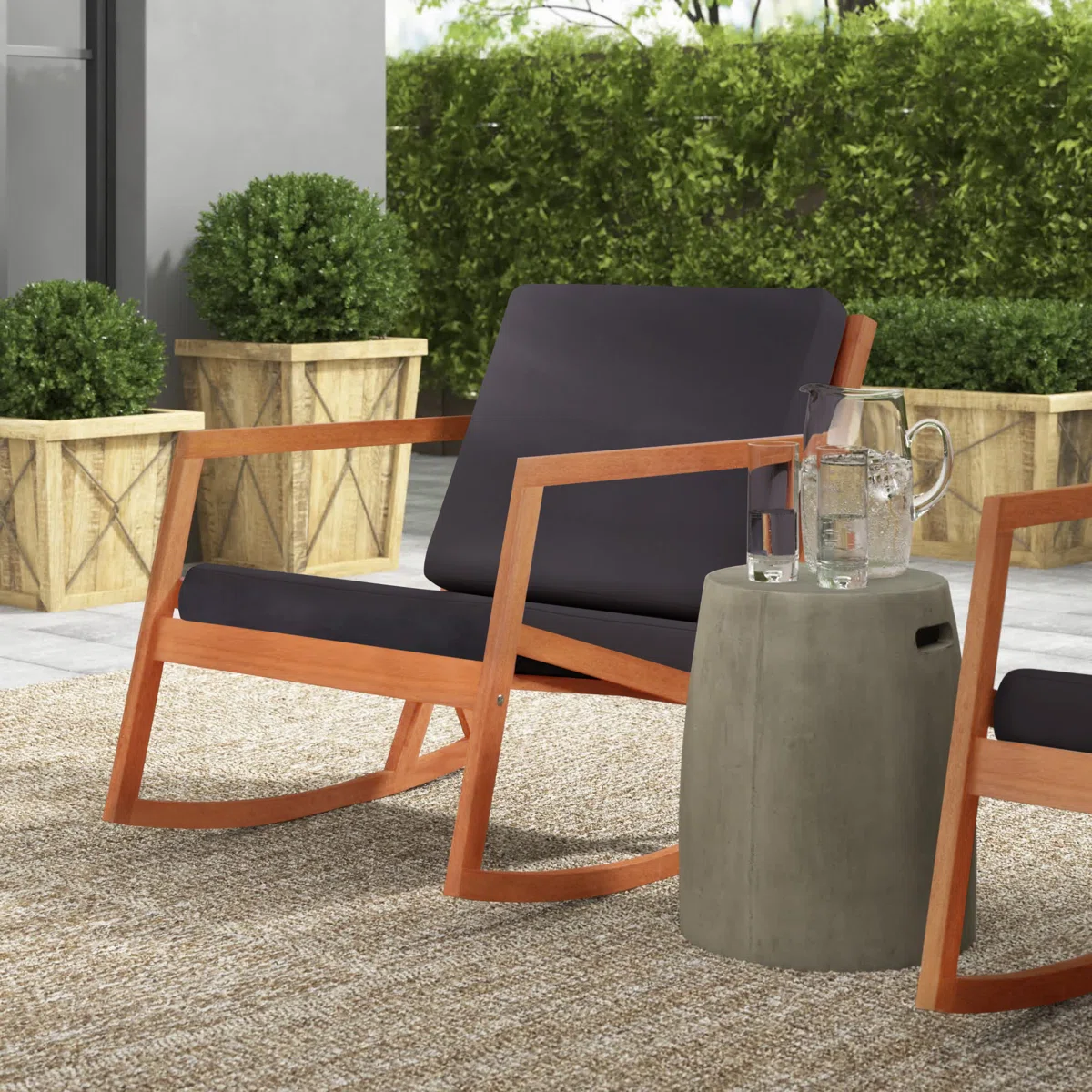 Kyron – Fauteuil à bascule extérieur en bois d’eucalyptus avec coussins