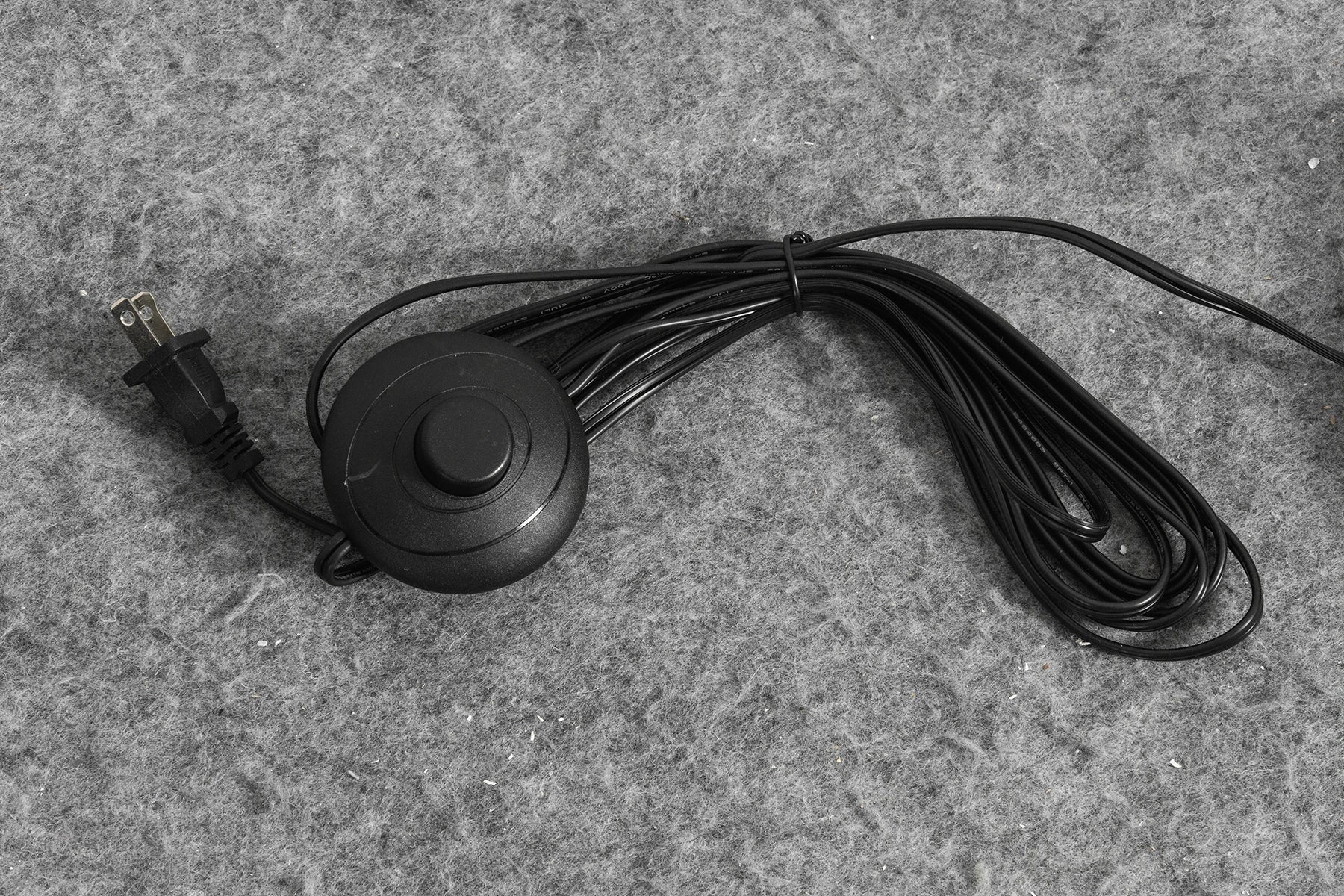 Round foot switch on the black cord of the Kelda folded paper floor lamp, with US plug