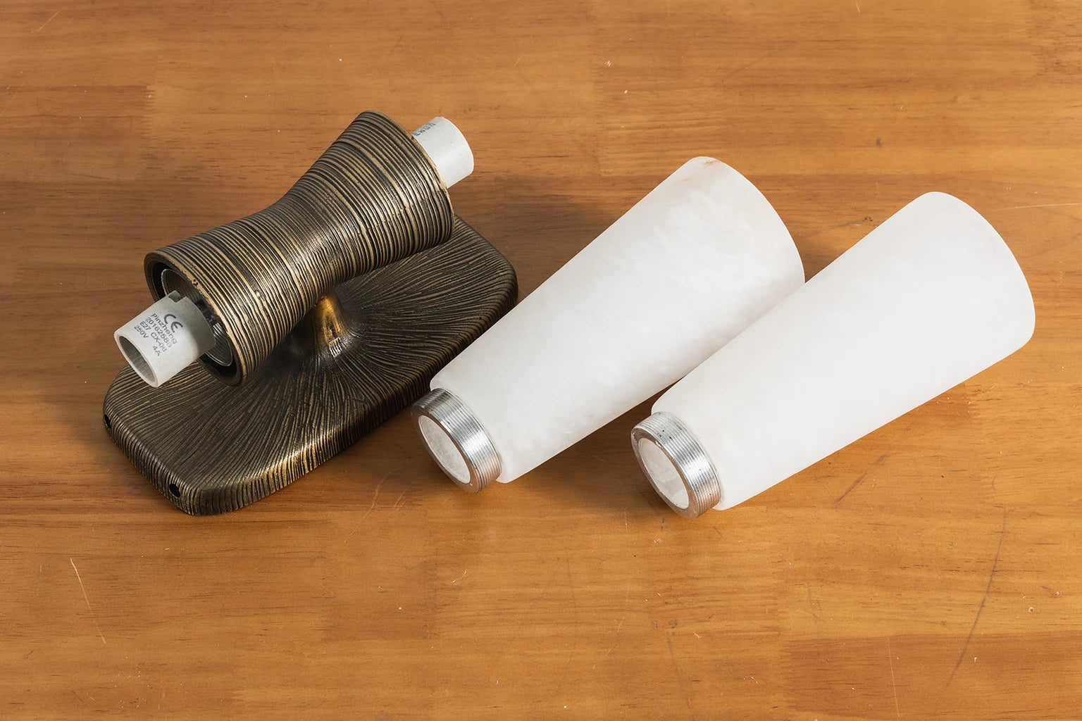 The modular parts and hardware that make up the twist tapered wall sconce