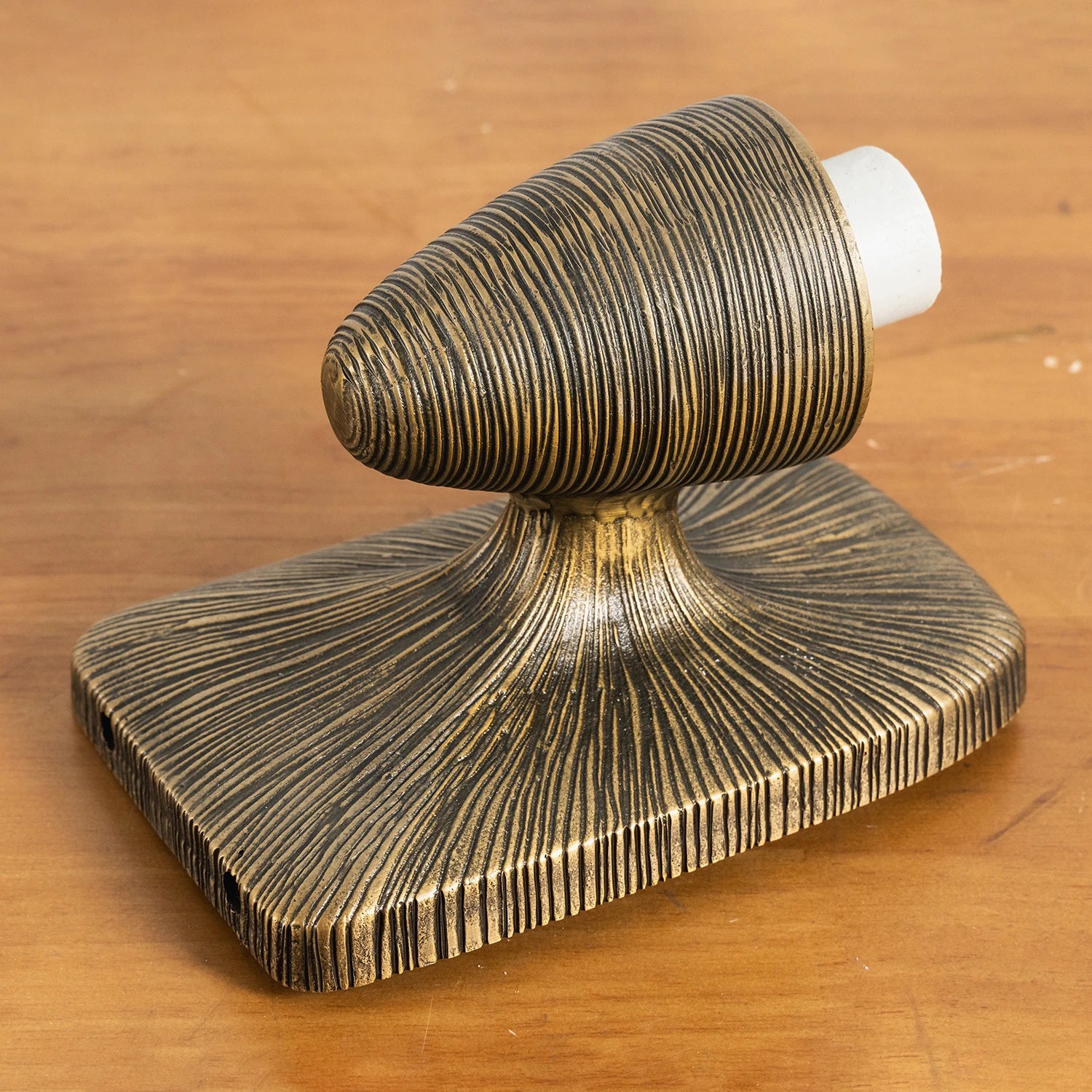 The sturdy metal frame and backplate of the wall sconce