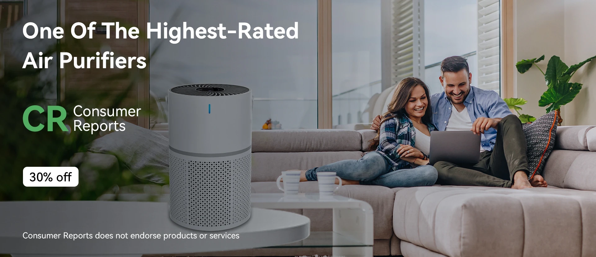 White cylindrical air purifier with perforated base and black top displayed on a table in a living room with a couple on a so