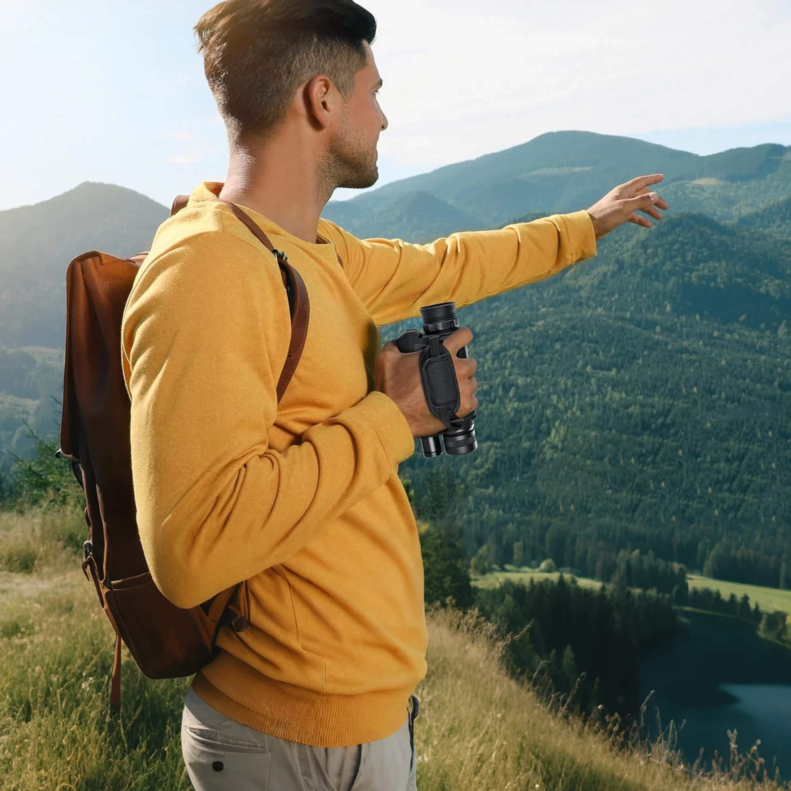 Man in mustard sweater carrying a brown leather backpack while overlooking forested mountains