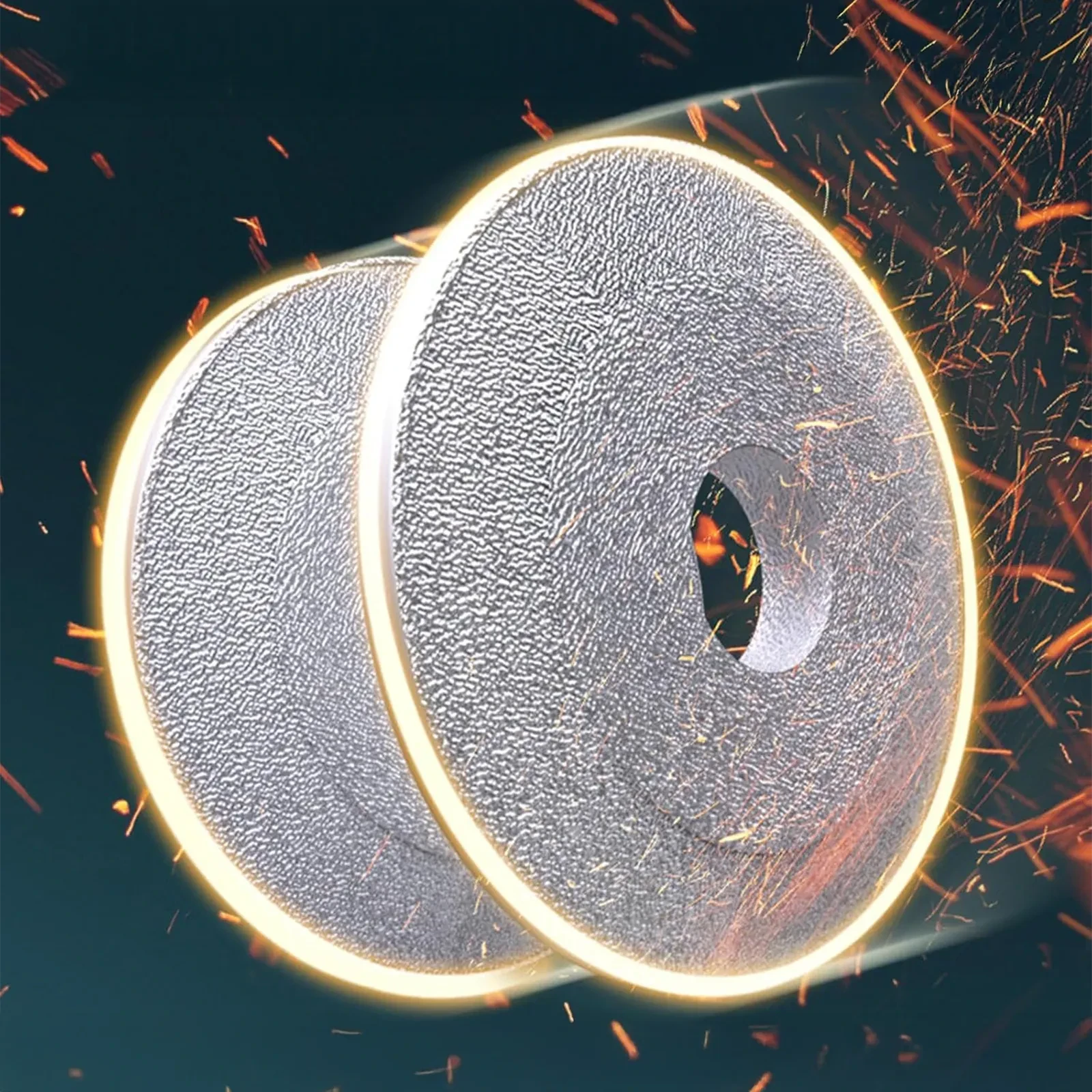 Two gray abrasive cutting discs with central arbor holes amid orange sparks during metal grinding