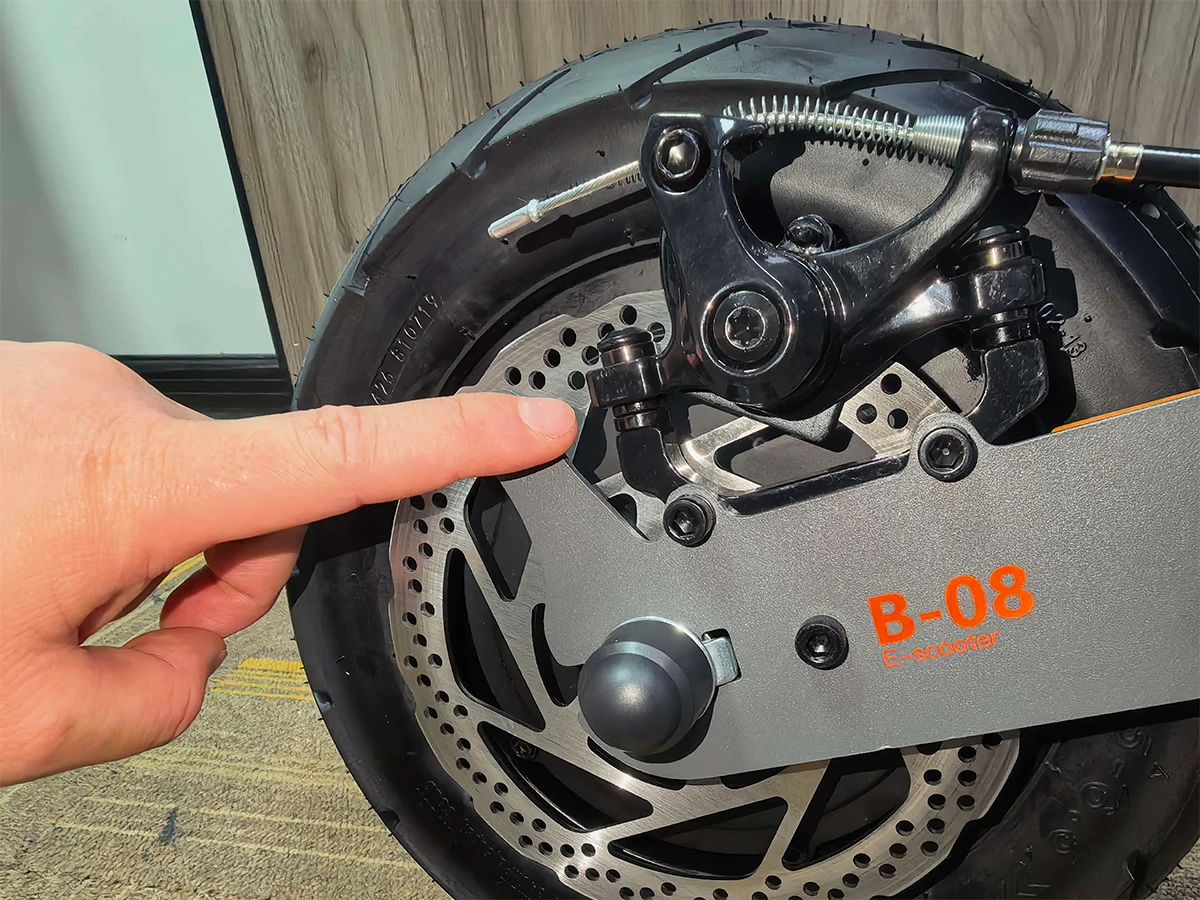 KuKirin G4 original rear brake caliper showing mounting bolts and metal washers