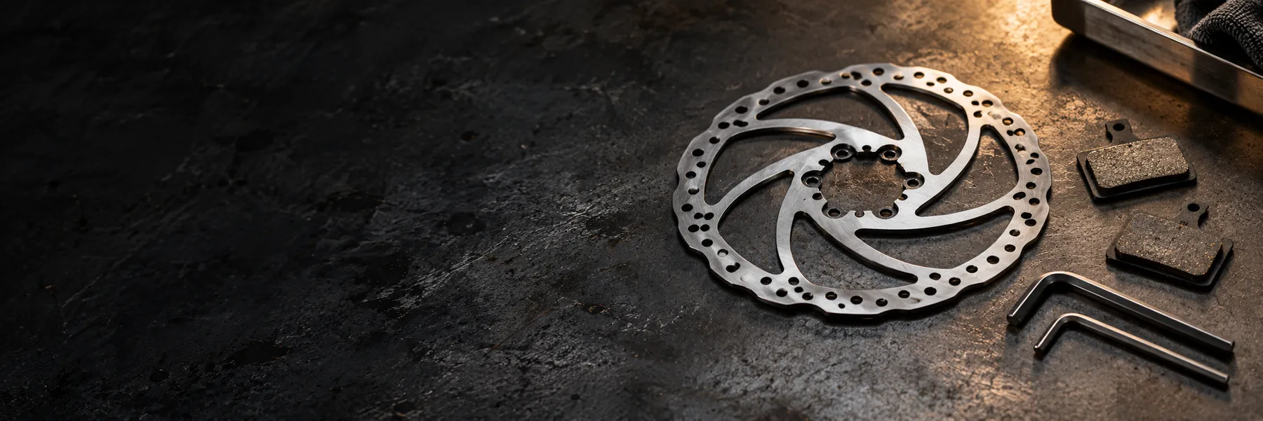 Brake rotor, pads and workshop tools — XOD brake guides editorial illustration
