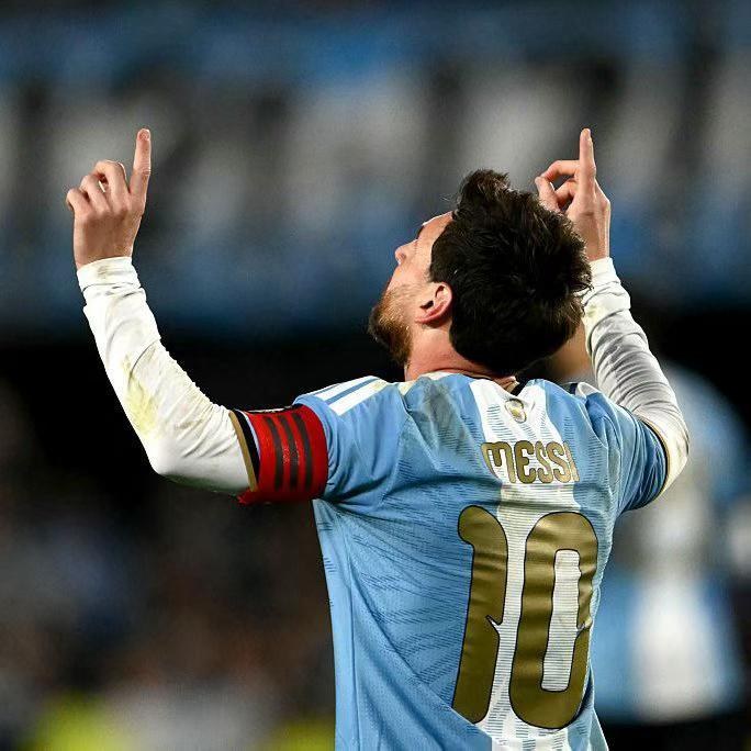 Messi with both arms raised as he leaves the pitch at the Estadio Monumental