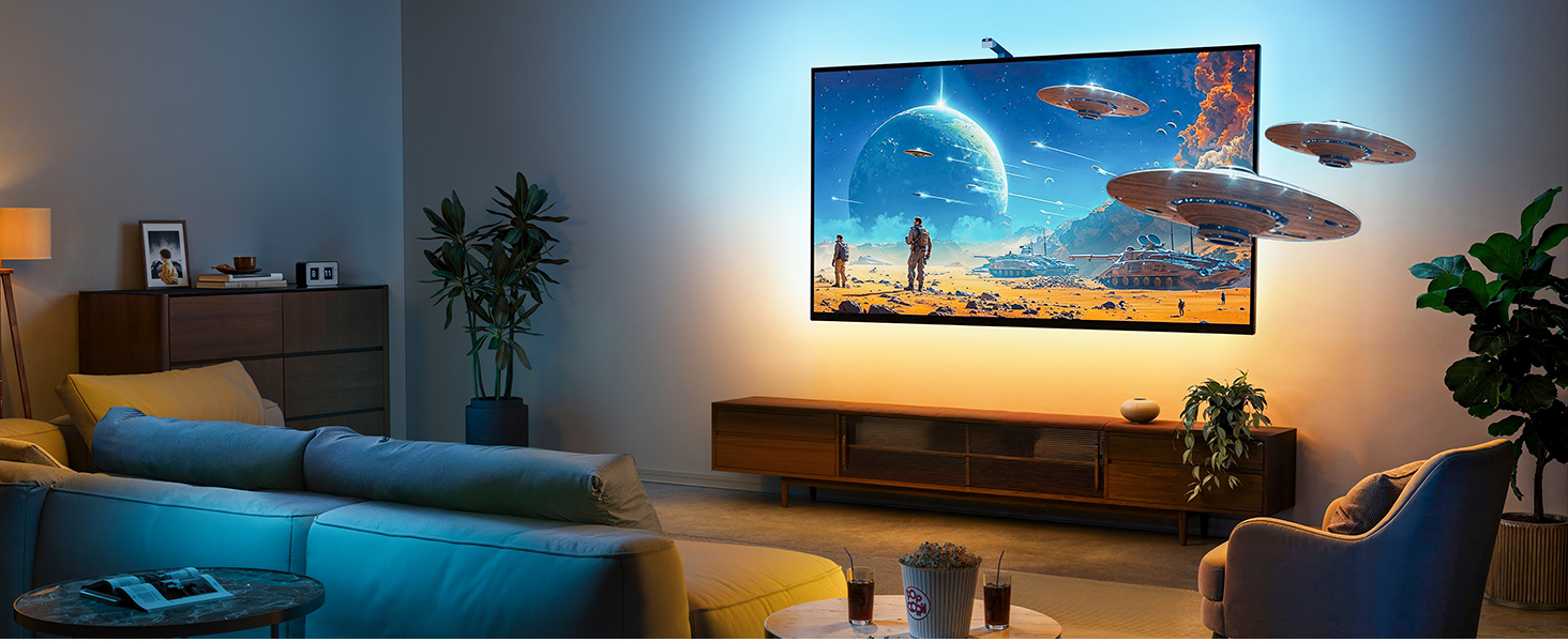 Large flat-screen TV mounted on wall displaying fantastical scene with planets and spaceships. TV extends 3D effect beyond screen. Living room setting with couch and ambient lighting.