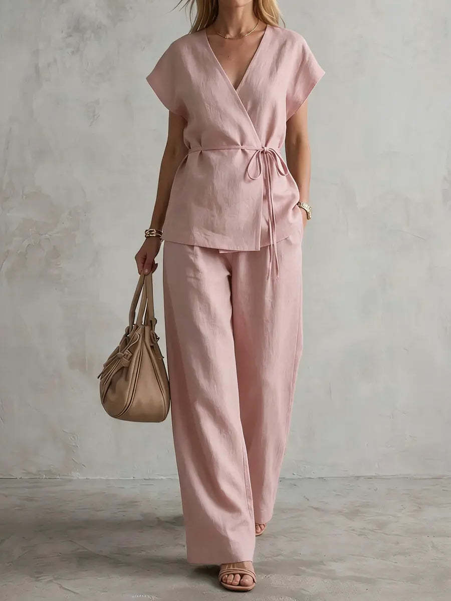 A woman wearing a wrap-front blouse with linen drawstring trousers for business travel