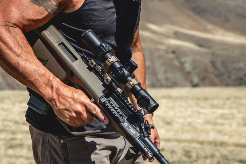 Tactical man holding a rifle with mounted Night Stalker Mini Weapon Mounted Scope.