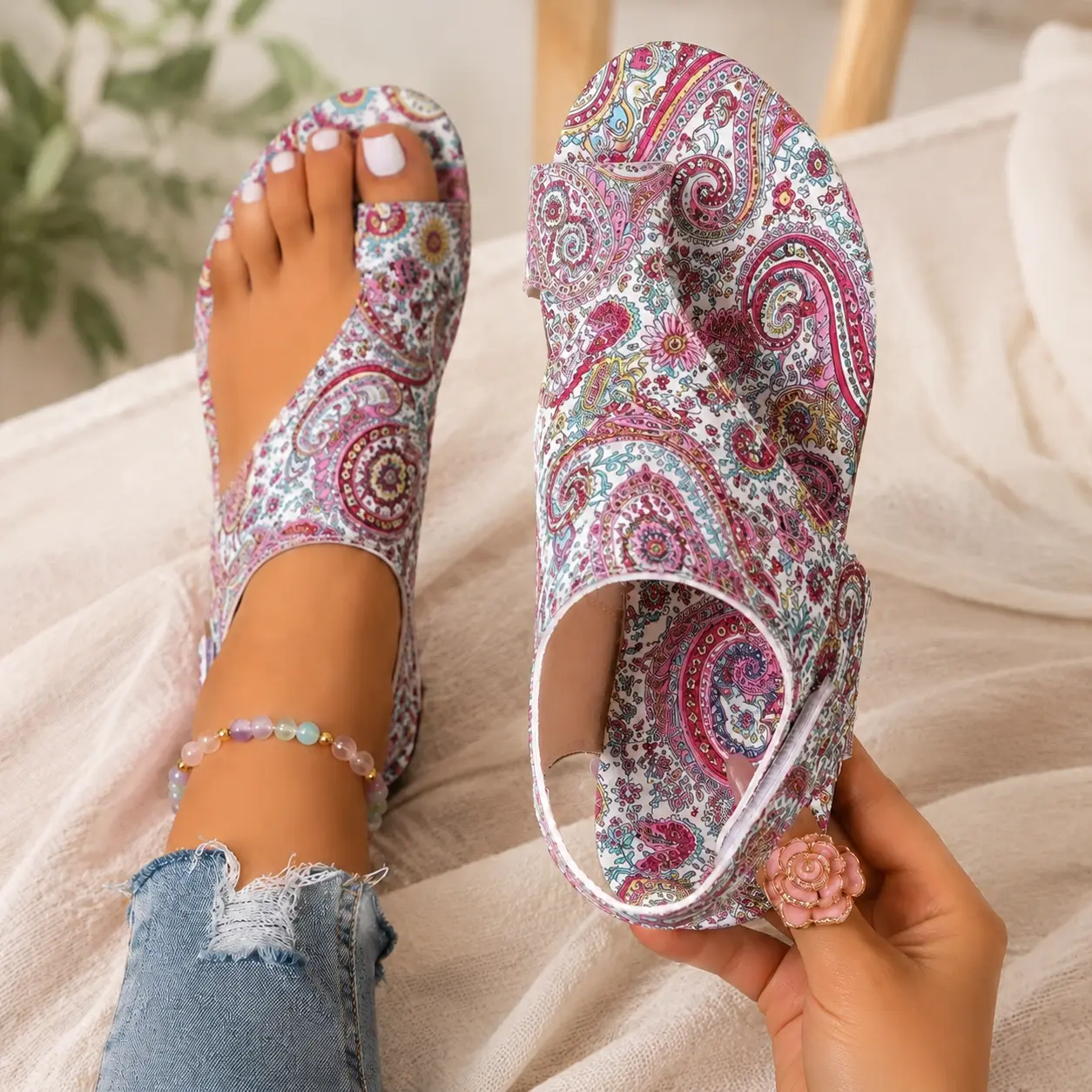 Pink and white paisley split-toe sandals showing the wraparound upper and side closure