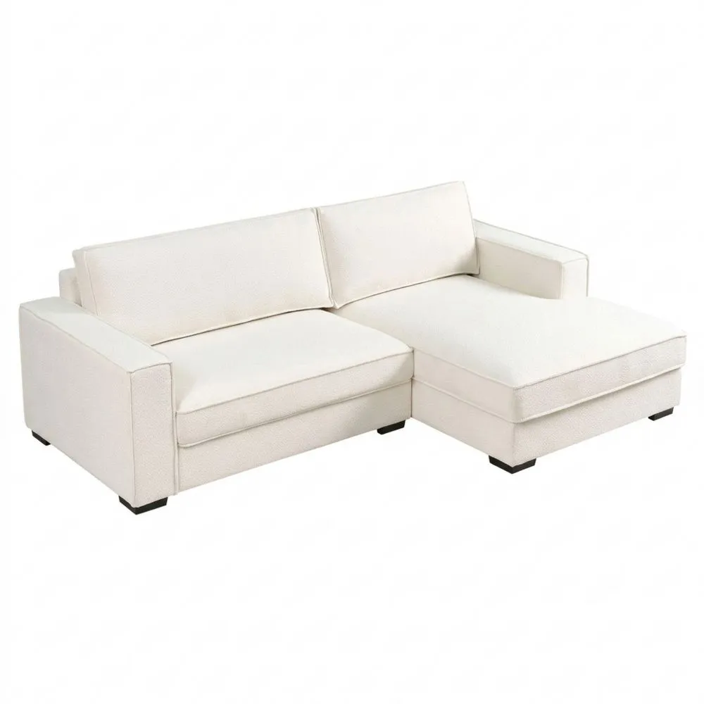 Sofá esquinero moderno de bouclé con cojines en blanco crema