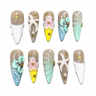 High-gloss ocean-themed press-on nails featuring 3D sculpted starfish, white seashells, mint green flowers, and pearl accents.
