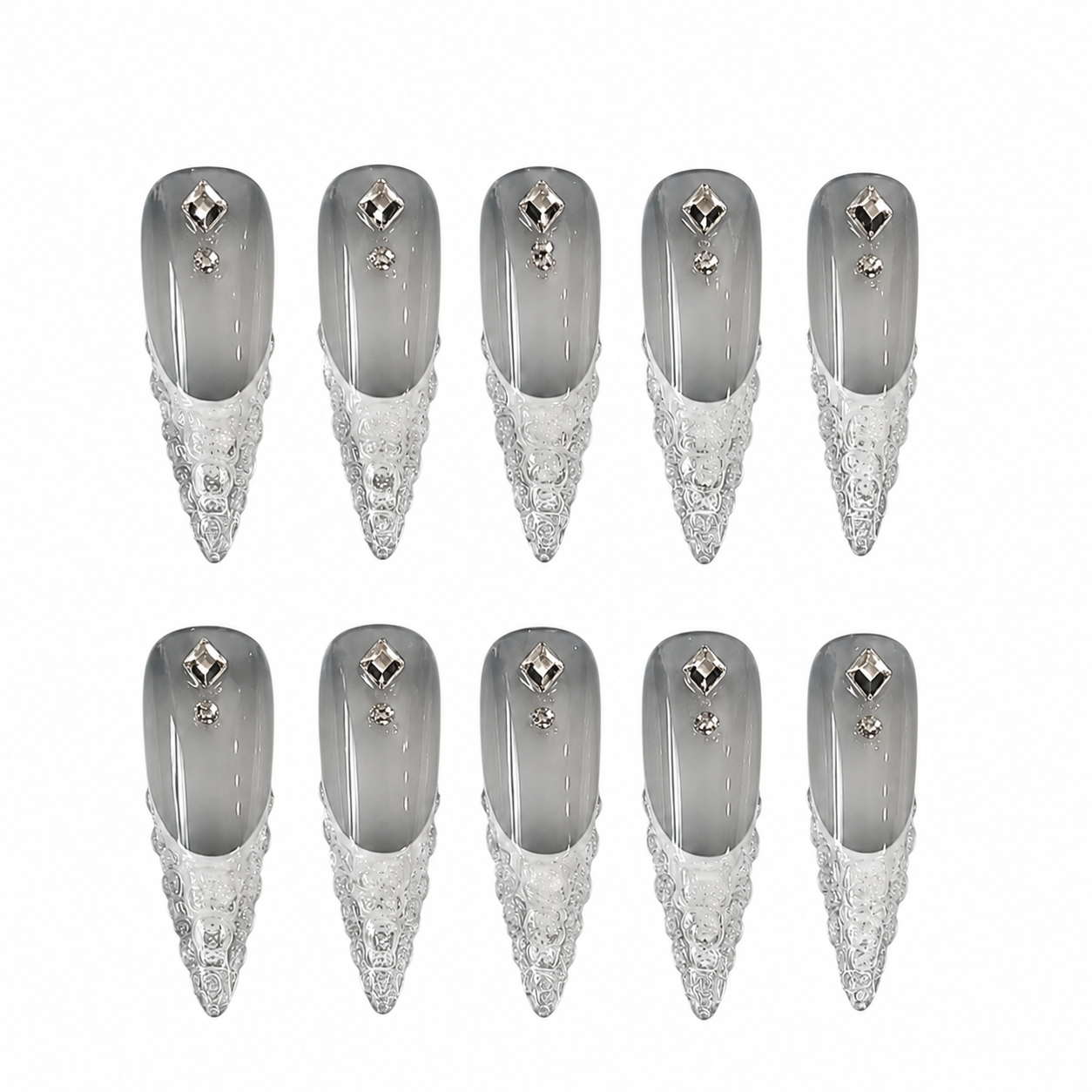 Glossy stiletto press-on nails featuring a smoky grey ombre base with 3D carved silver metallic tips and diamond rhinestones.