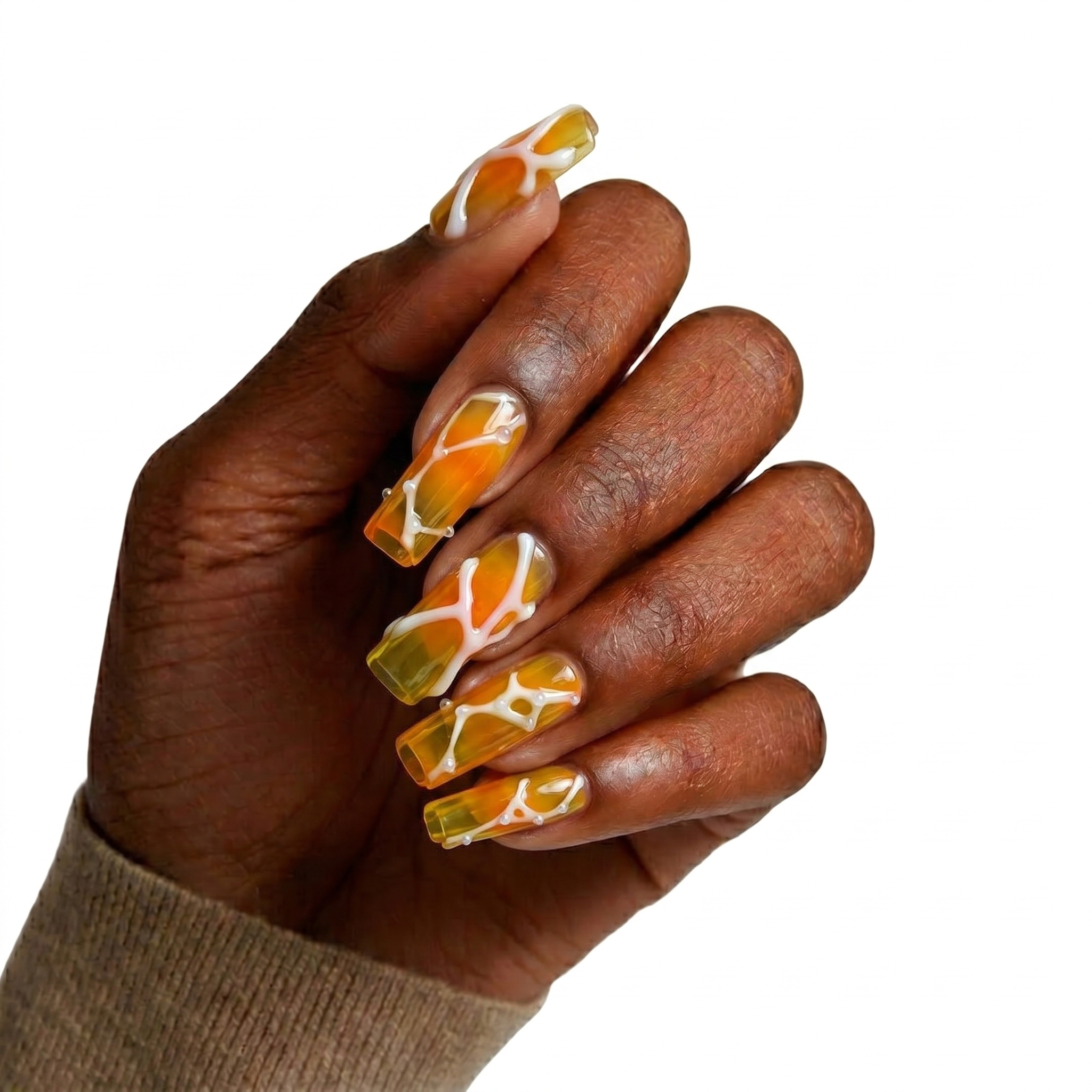 Glossy coffin press-on nails with a translucent orange amber ombre base, wrapped in 3D fluid white lines and dots.