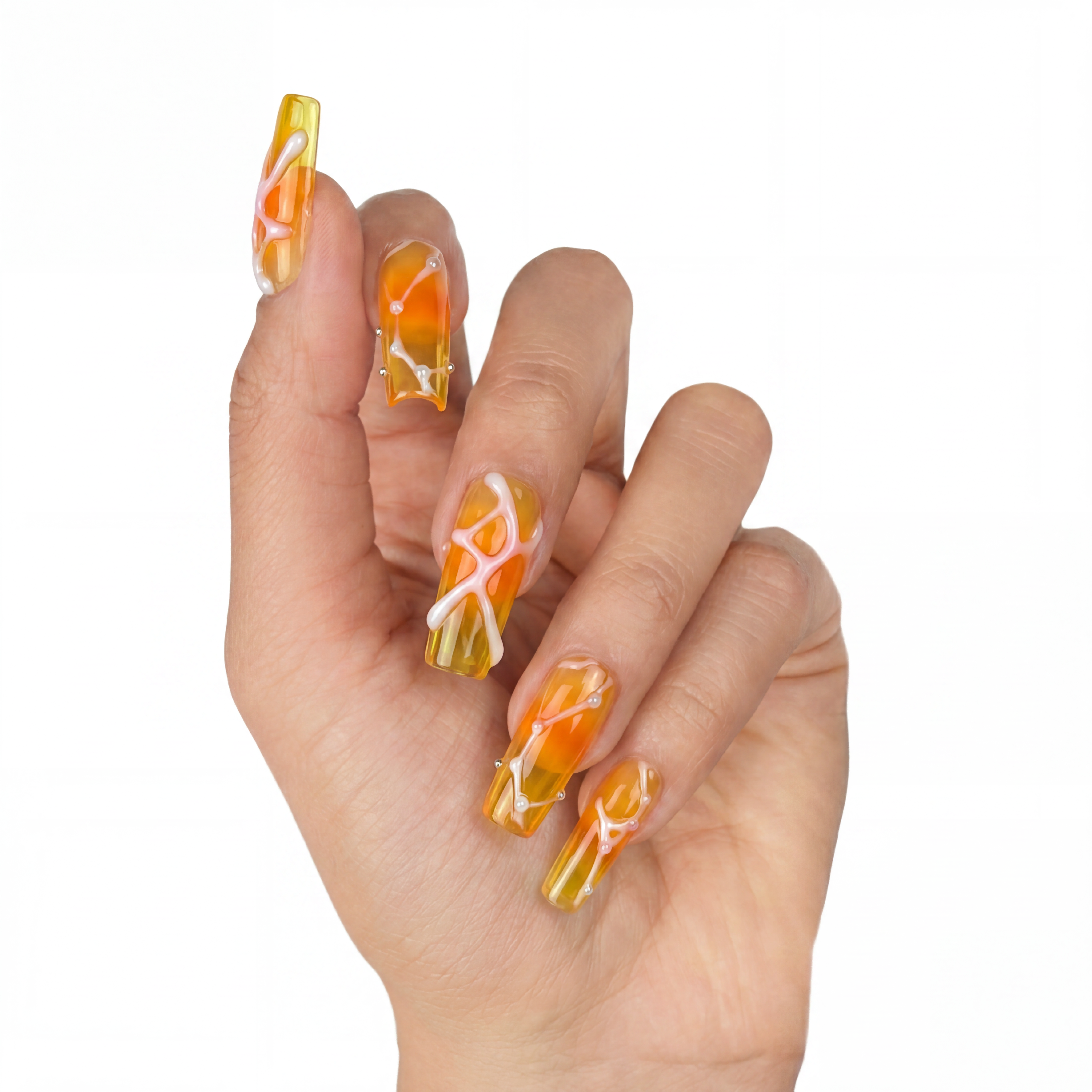 Glossy coffin press-on nails with a translucent orange amber ombre base, wrapped in 3D fluid white lines and dots.