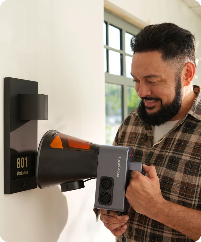 Handheld vertical engraving with LaserPecker LP2 Plus, showing a creator laser-etching a