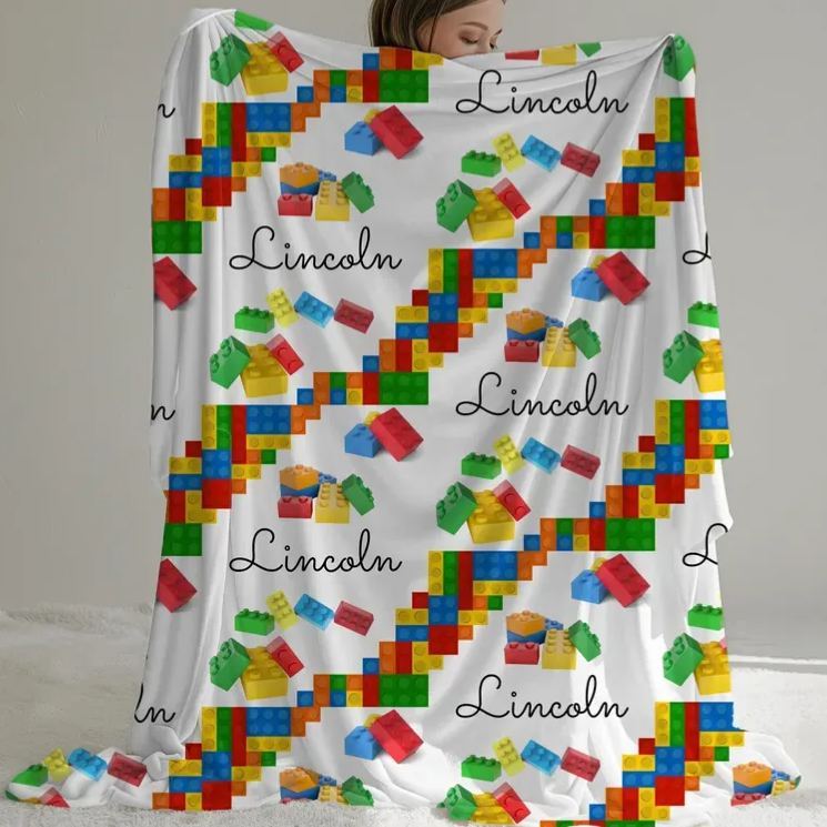 Gepersonaliseerde plaid met bouwblokken en naam, decoratieve deken voor op de bank of bank met bouwstenenmotief.