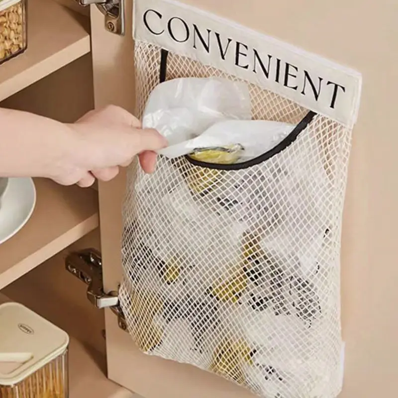 Wall-mounted mesh trash bag organizer inside kitchen cabinet