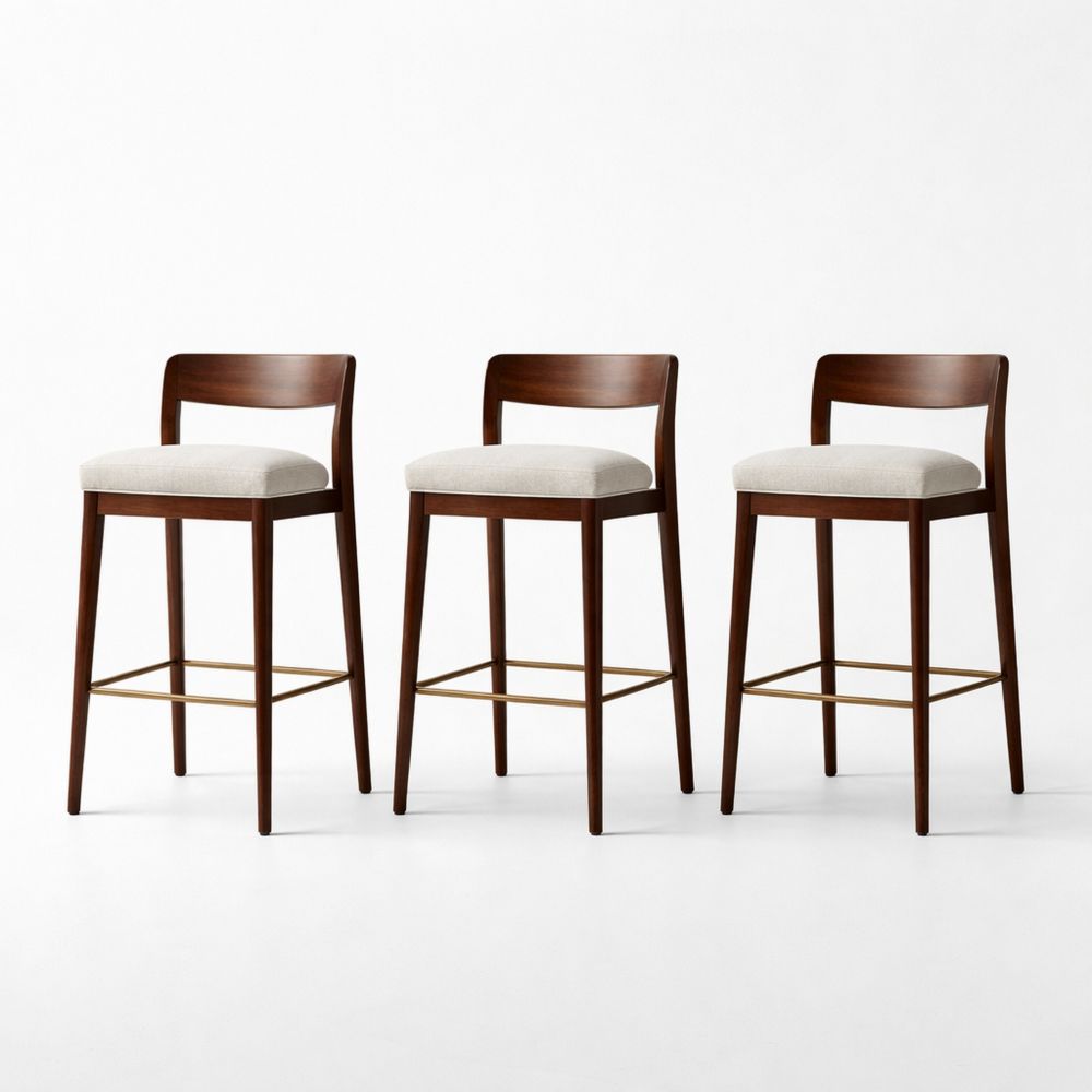 Set of three wooden bar stools with fabric cushions and brass footrests