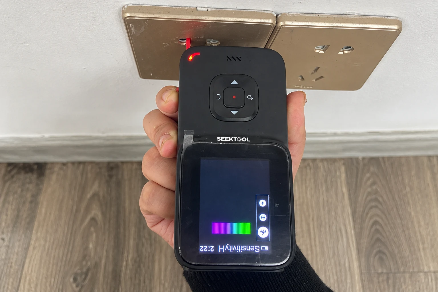 STRATA PRO is held upside down with its red voltage sensor near an outlet
