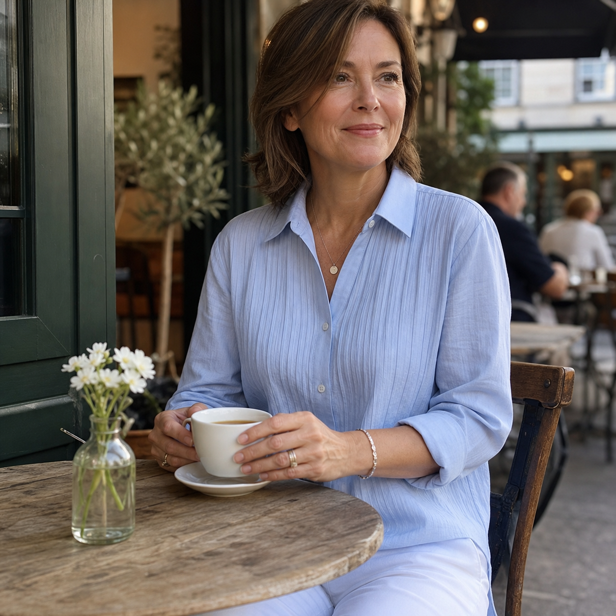 Customer in soft blue pleated cotton-linen shirt at an outdoor cafe