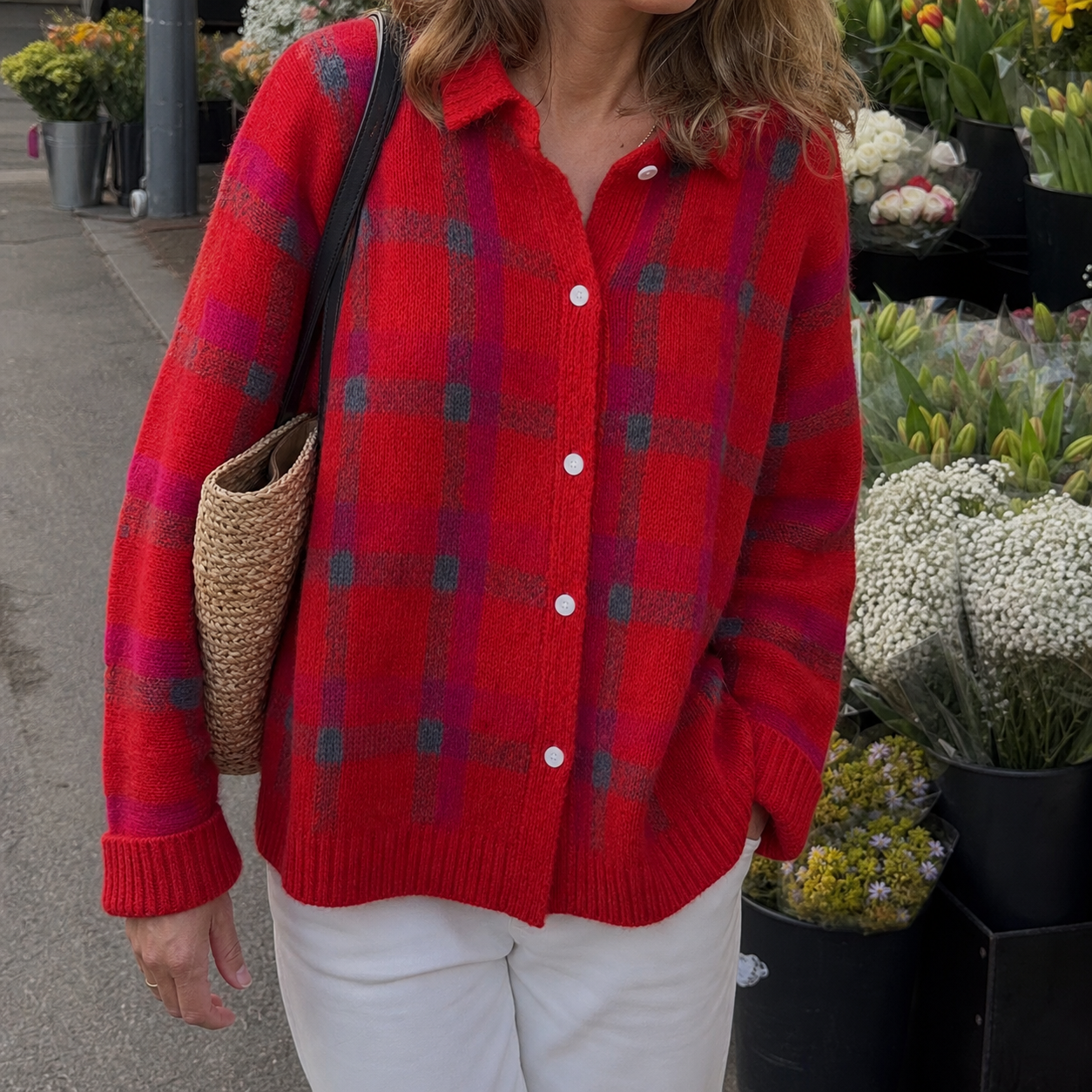 Red contrast-plaid knit cardigan at a flower market