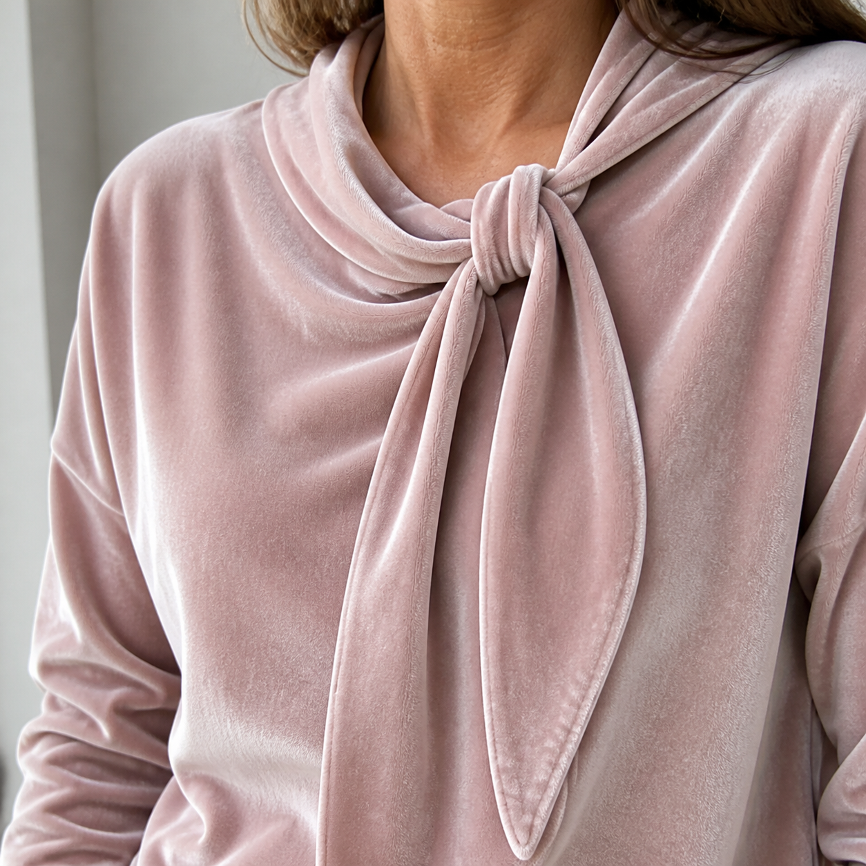 Close view of the Blush Pink velvet texture, draped neckline and bow