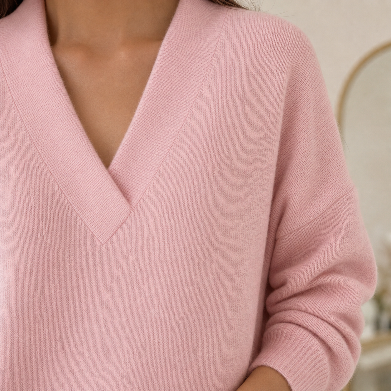 Close view of the pink sweater V-neck trim and ribbed cuff