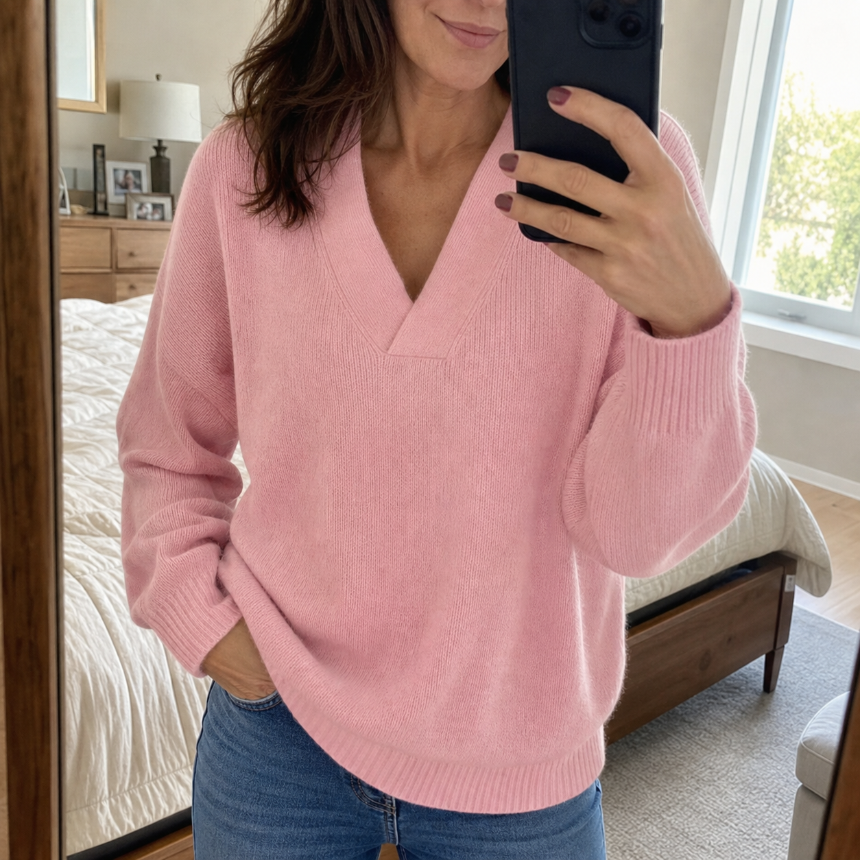 Customer mirror selfie in the pink V-neck sweater