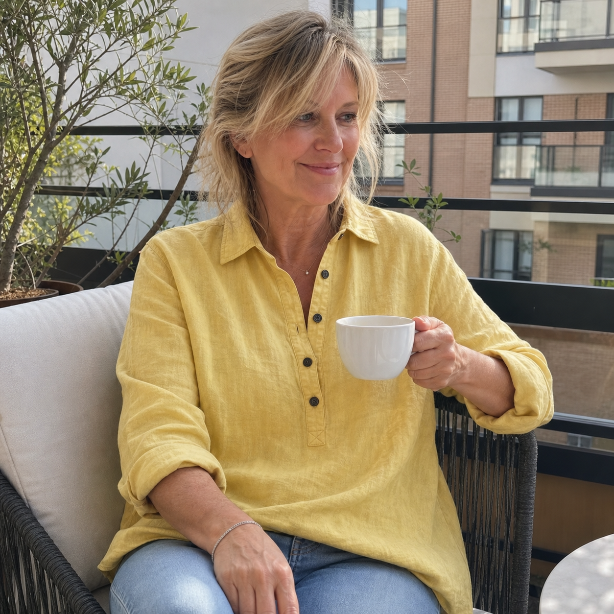 Customer wearing the yellow linen Henley on a balcony