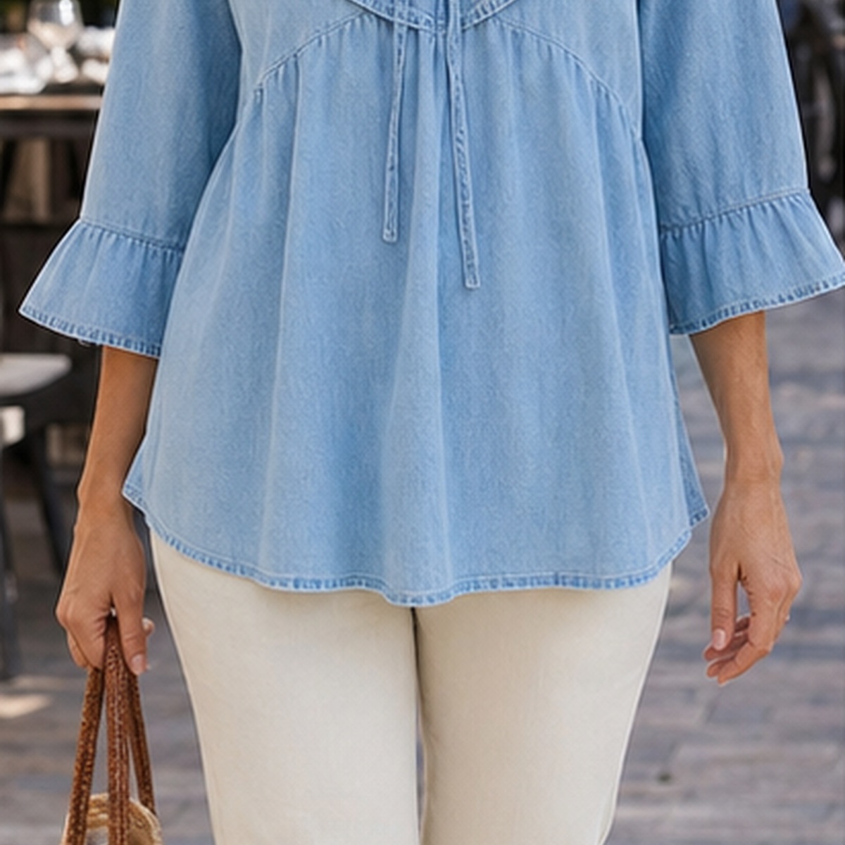 Mature woman wearing a light blue ruffle blouse in a lifestyle scene