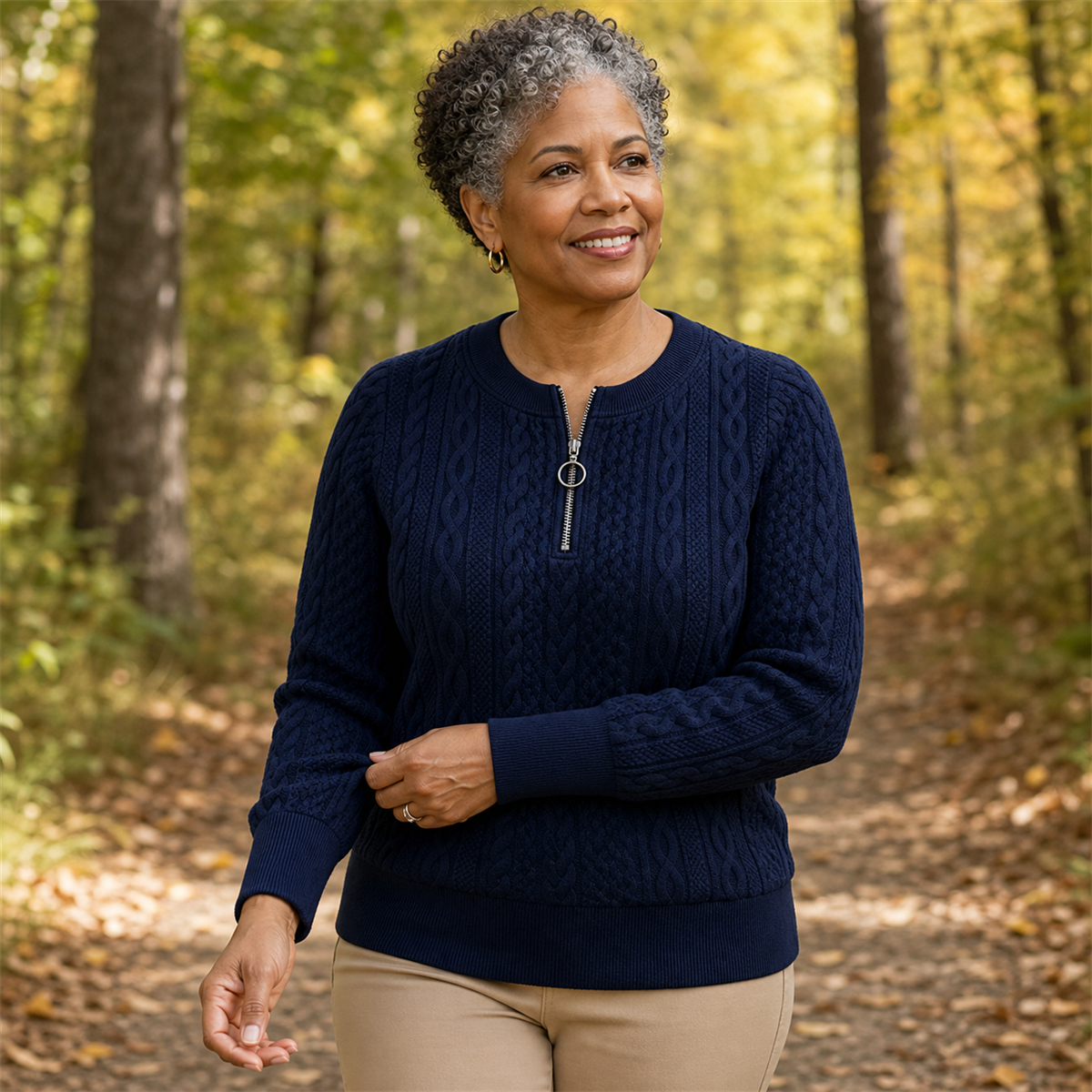 Woman wearing a navy cable-knit quarter-zip pullover on a woodland trail