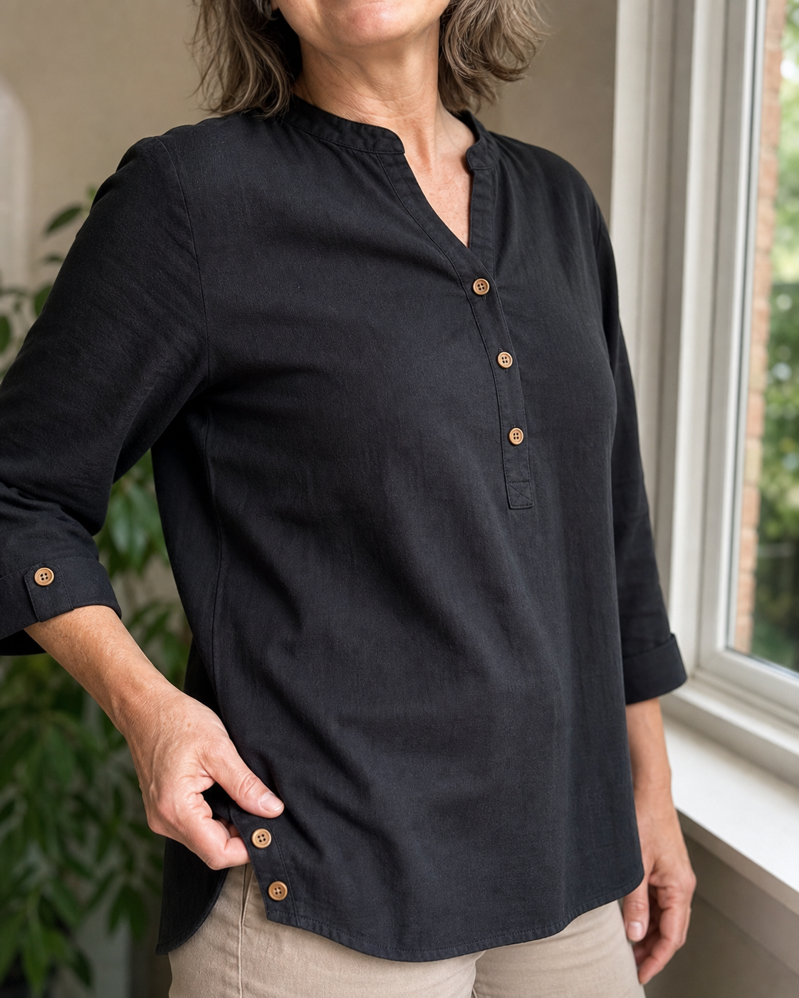 Woman styling the band-collar blouse in black