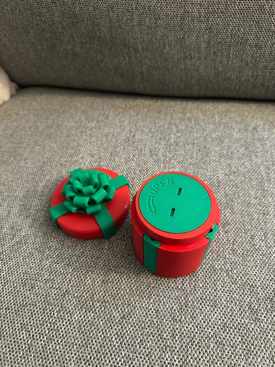 Alex's red and green prank gift box displayed on a sofa