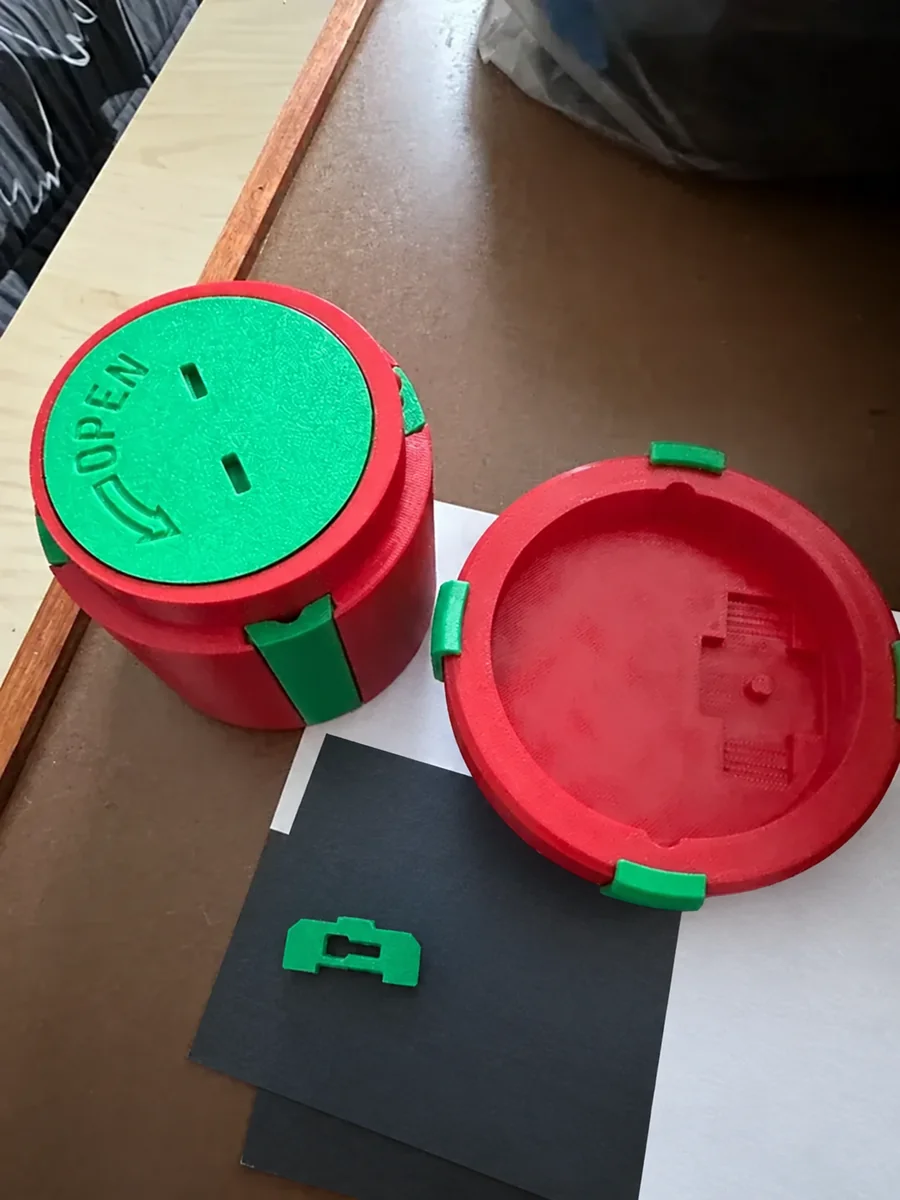 Emily's red and green layered prank money box opened beside its lid