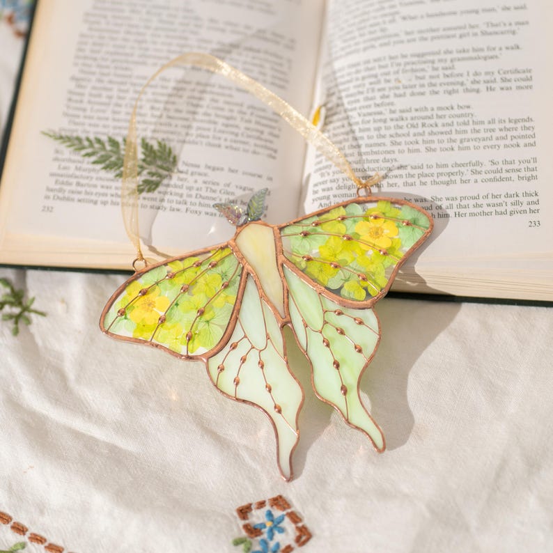 Apanhador de sol de vitral em forma de mariposa com flor prensada para janela, decoração que captura a luz.