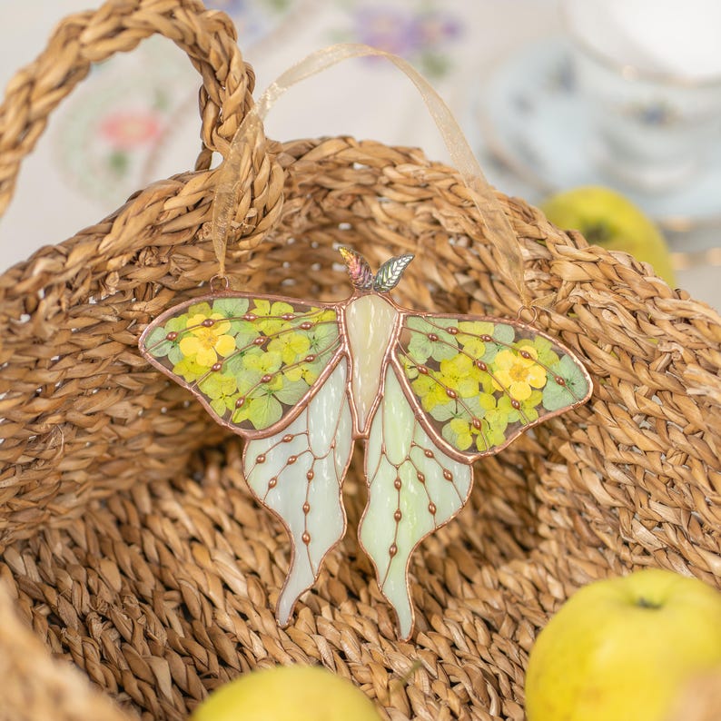 Apanhador de sol de vitral em forma de mariposa com flor prensada para janela, decoração que captura a luz.