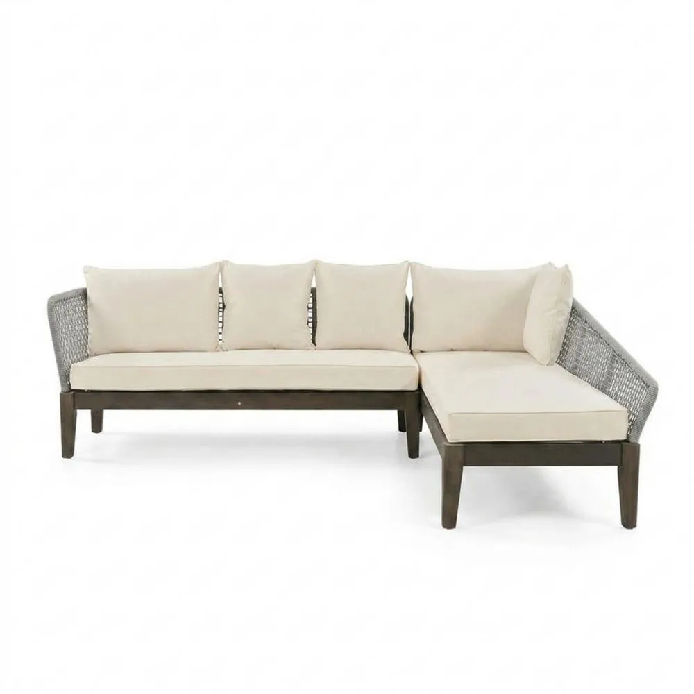 Divano angolare a L in legno massello e rattan sintetico con cuscini beige.