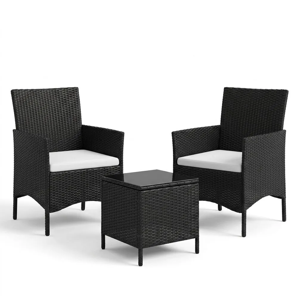 Conjunto de tres piezas de muebles de jardín de ratán sintético y cristal negro con cojines blancos.