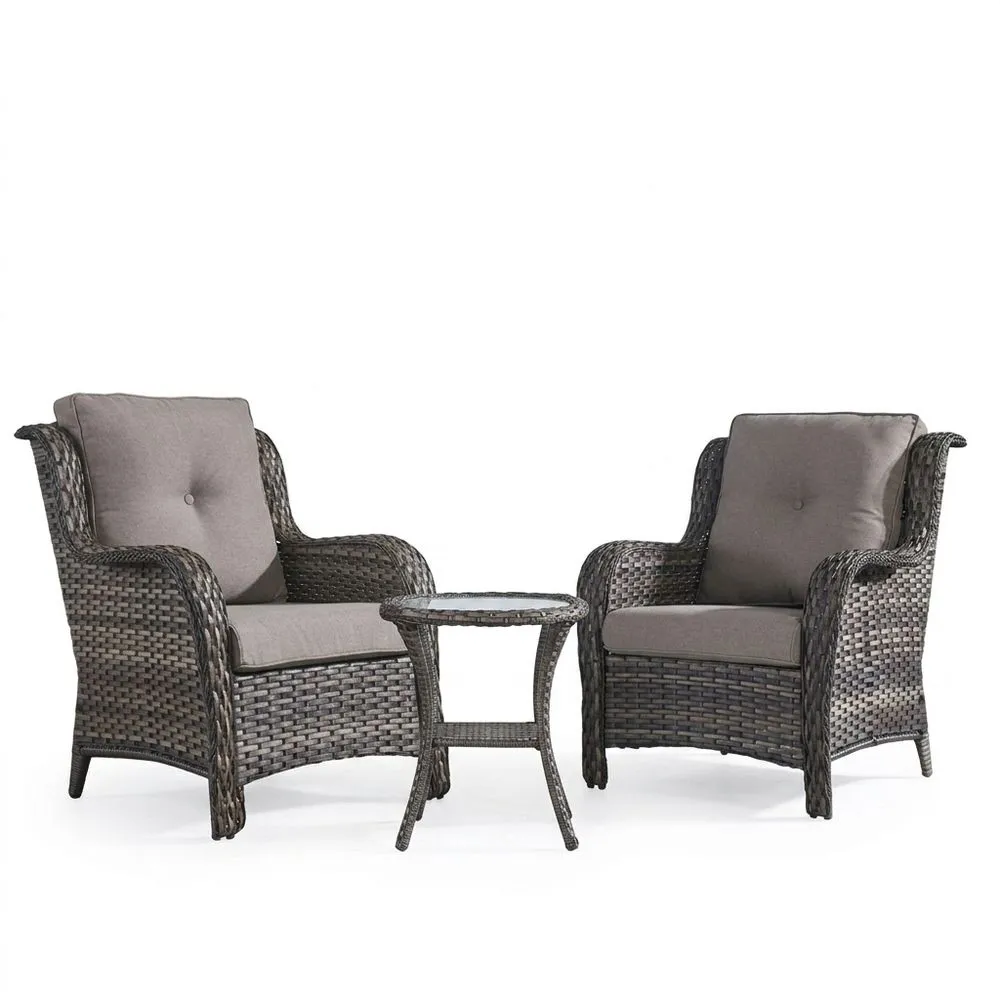 Sillón y mesa de ratán sintético con cojines de asiento grises.